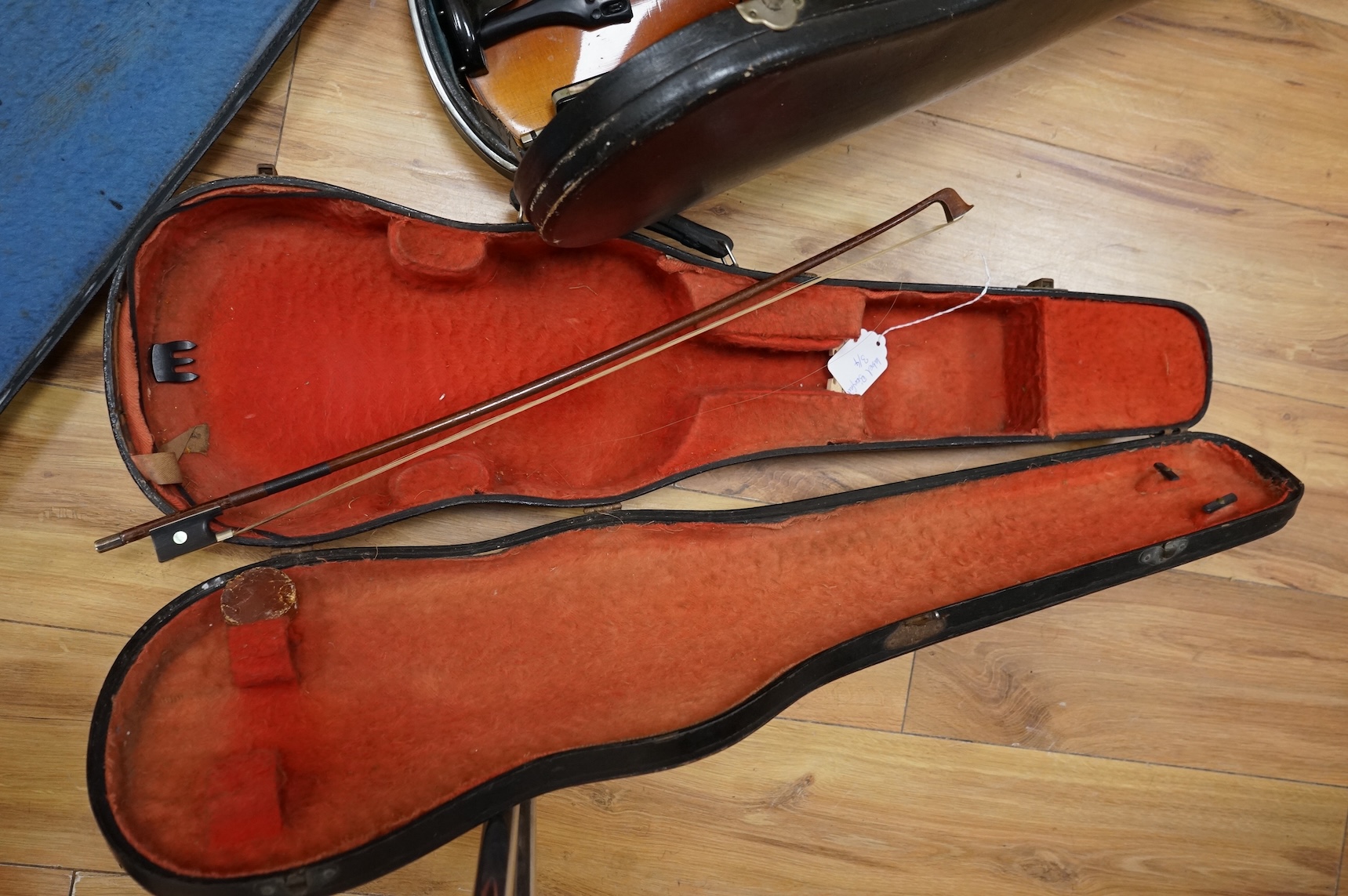 Five cased 20th century violins, including; a German violin, two Czech violins, a three-quarter size violin with a label for Bienfait, and a Romanian quarter size violin, all in cases or the remains of cases.